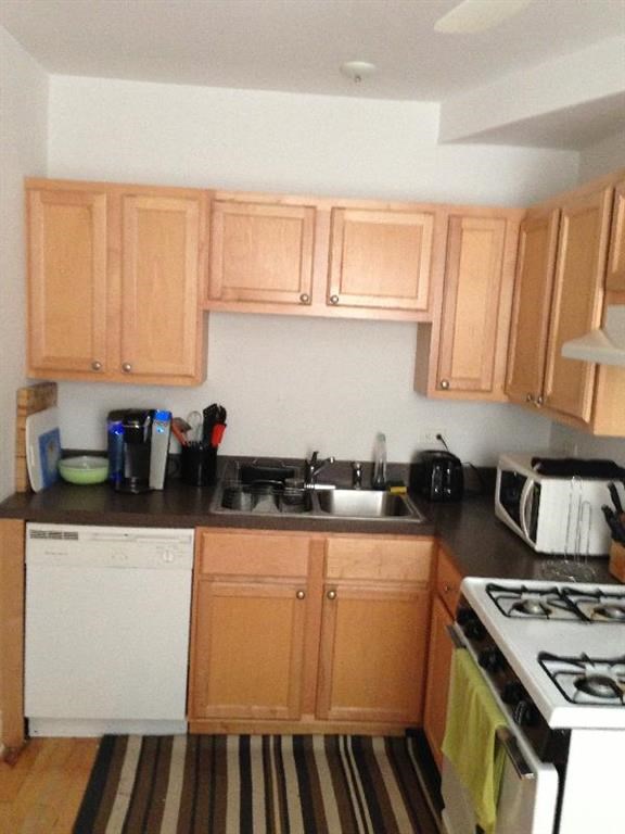 a kitchen with wooden cabinets and a stove and a sink