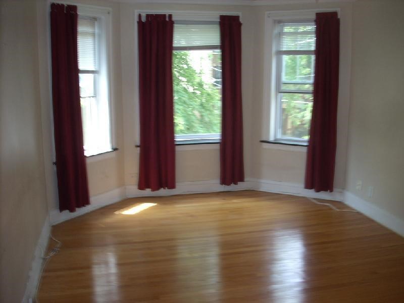 a empty room with red curtains and a wood floor