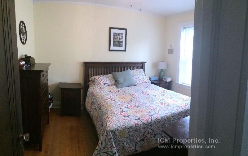 a bedroom with a bed and a dresser and a window