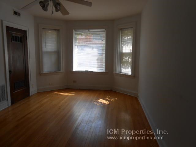 an empty living room with wood floors and a window