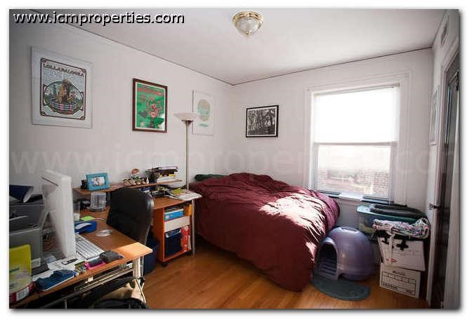 a bedroom with a bed and a desk and a window