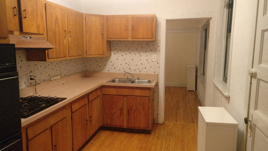 an empty kitchen with wooden cabinets and a sink