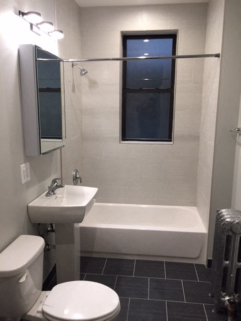 a bathroom with a sink toilet and a window