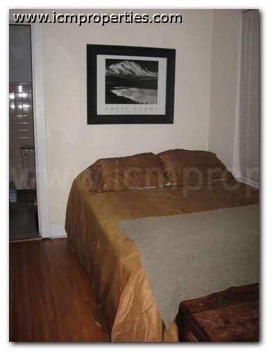 a bedroom with a bed and a picture on the wall