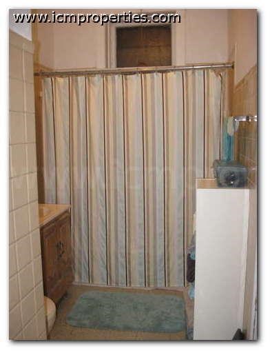 a bathroom with a shower with a white shower curtain