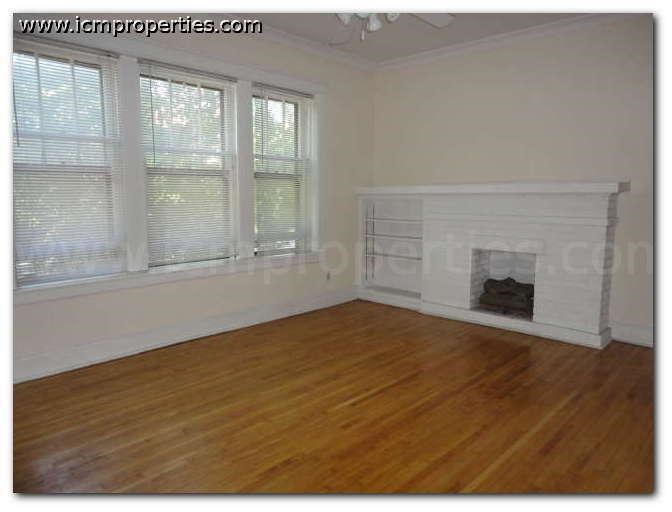 a living room with a fireplace and a wooden floor