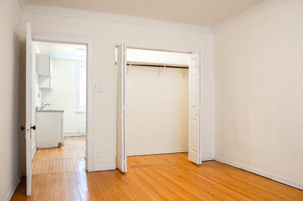 a empty bedroom with a closet and a door open
