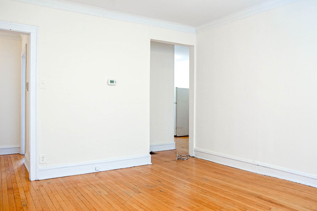 an empty room with a wooden floor and white walls