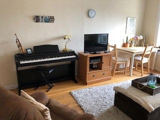 a living room with a piano and a tv