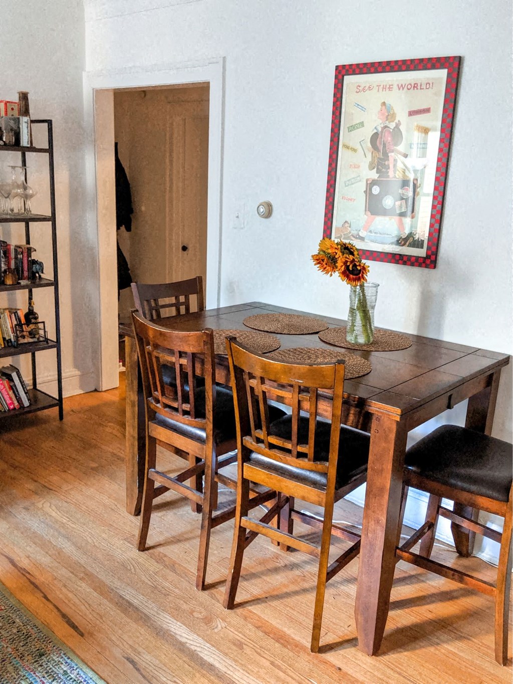 a dining room table with chairs and a mirror on the wall
