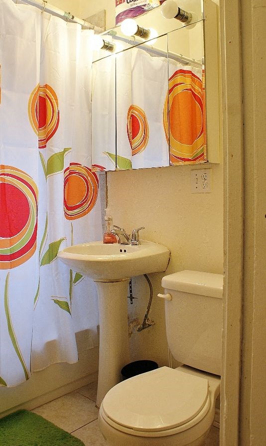a bathroom with a toilet and a sink and a shower curtain
