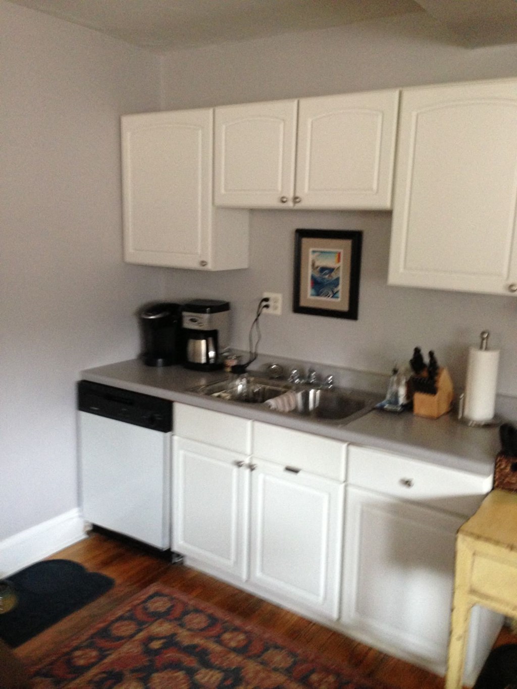 a small kitchen with white cabinets and a sink