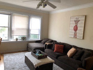 a living room with a couch and a ceiling fan