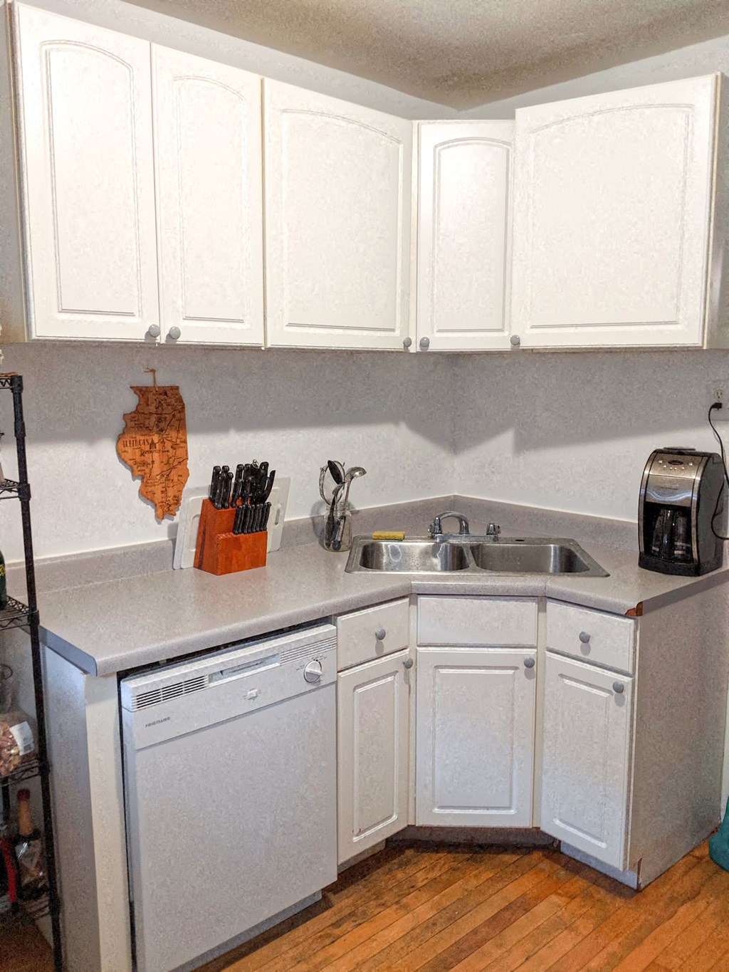 a kitchen with white cabinets and a sink and a dishwasher