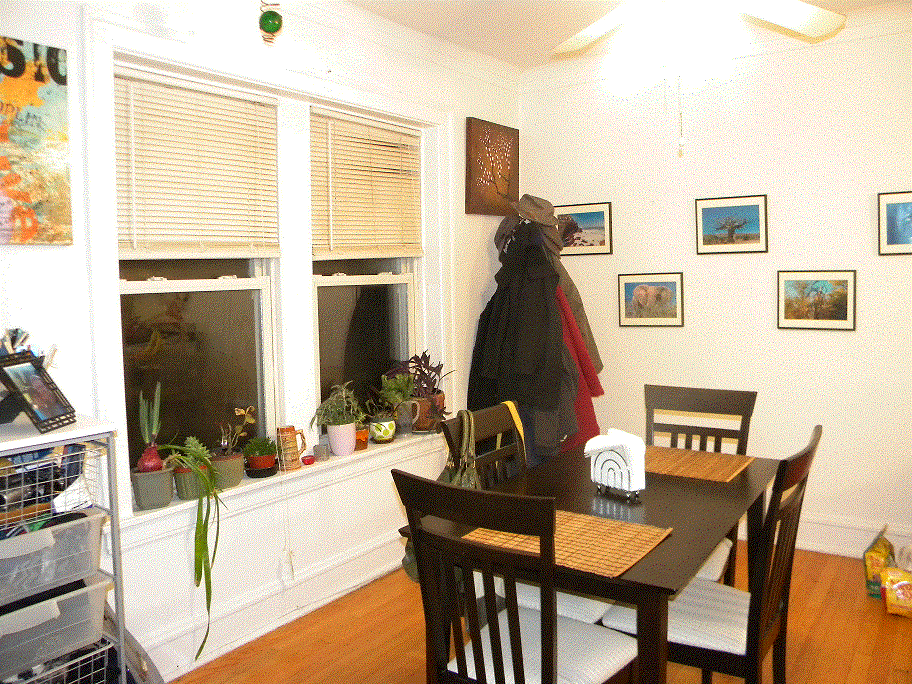 a dining room with a table and chairs      and a window