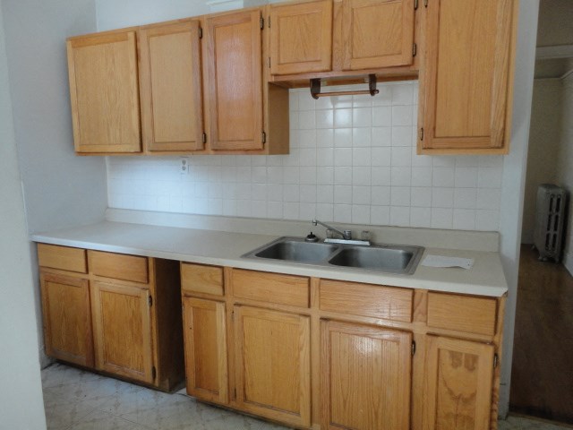 an empty kitchen with wooden cabinets and a sink