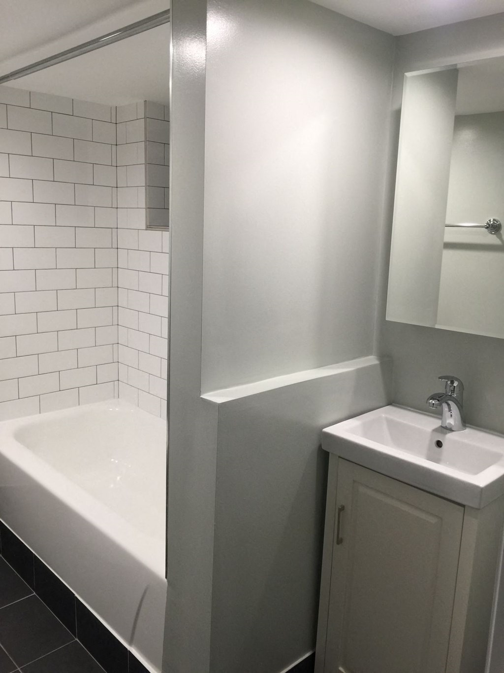 a white bathroom with a sink and a tub