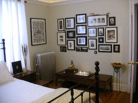 a bedroom with a bed and a picture gallery on the wall