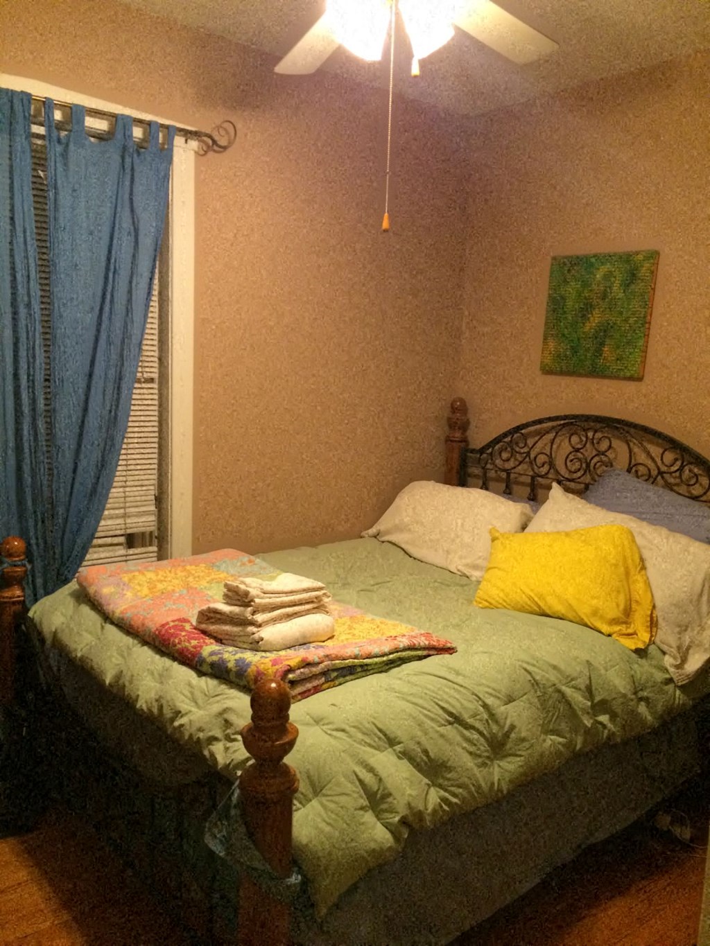 a bedroom with a bed with a blanket and pillows