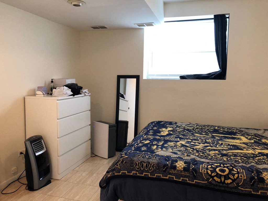 a bedroom with a bed and a dresser and a window