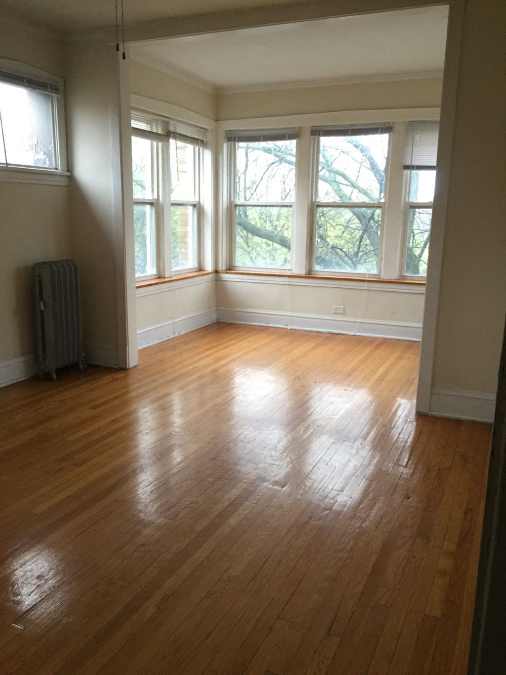 an empty living room with wood floors and windows