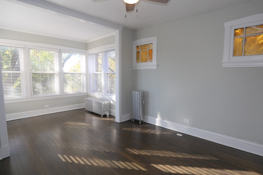 an empty living room with wood floors and windows