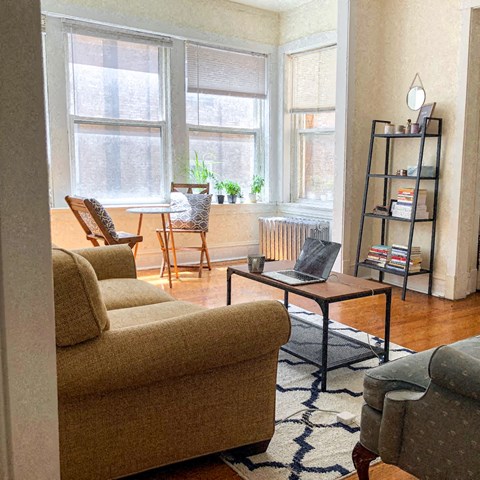 a living room with a couch and a laptop on a coffee table