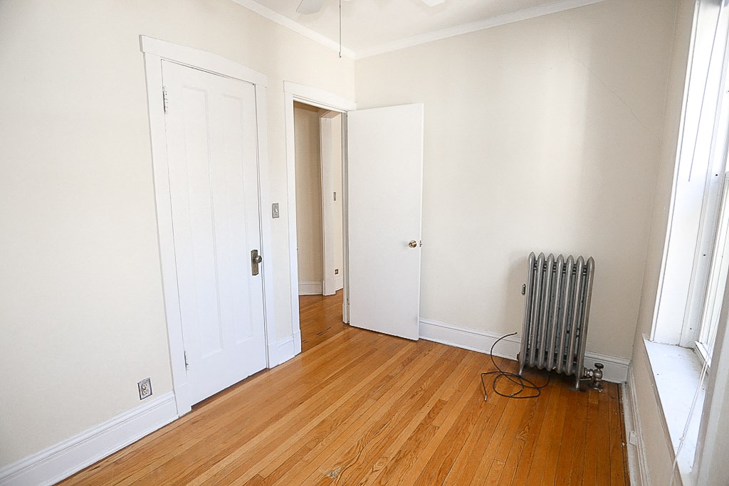 an empty room with two doors and a radiator