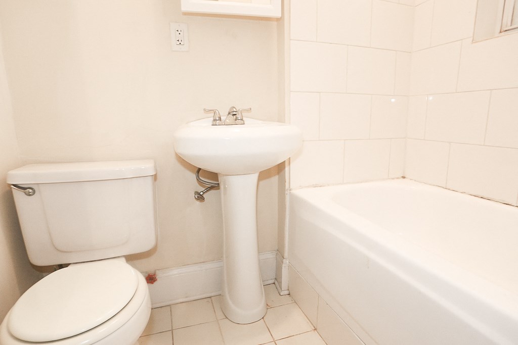 a white bathroom with a sink toilet and tub