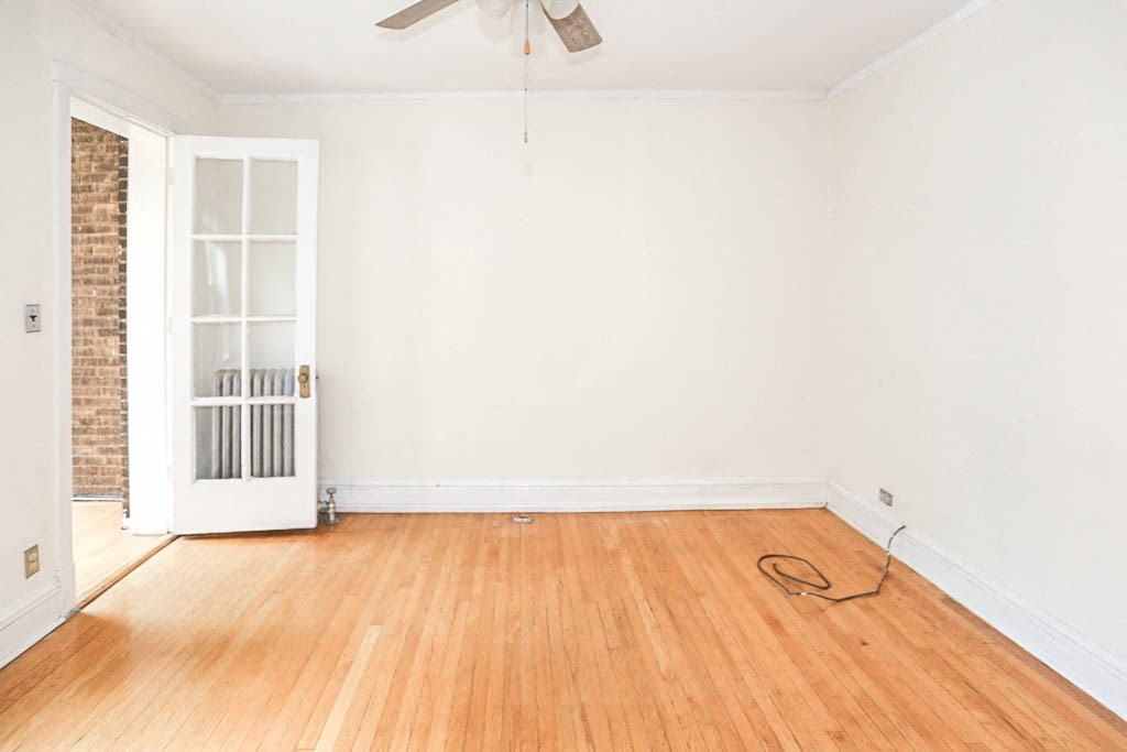 an empty room with a wood floor and a ceiling fan