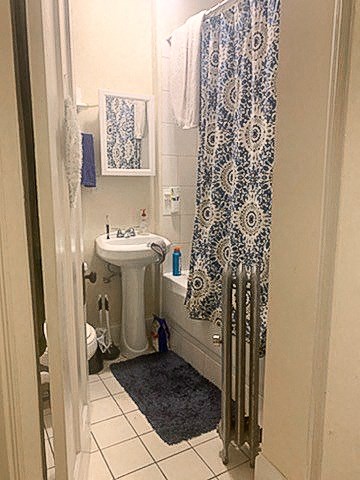 a small bathroom with a sink and a shower curtain