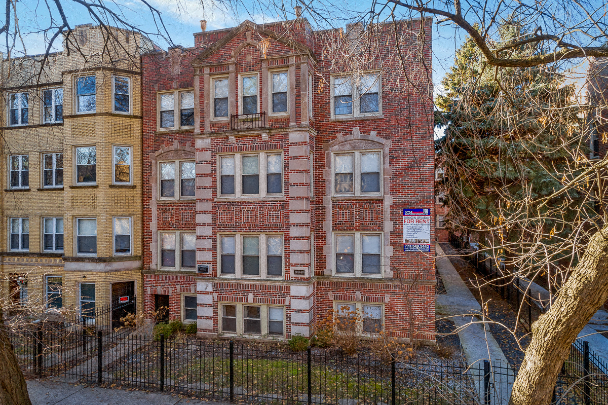 an old brick building with a fence in front of it