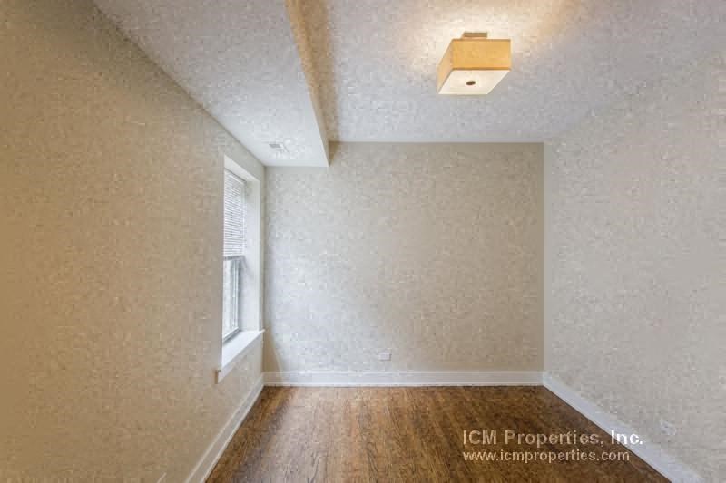 an empty room with a window and white walls