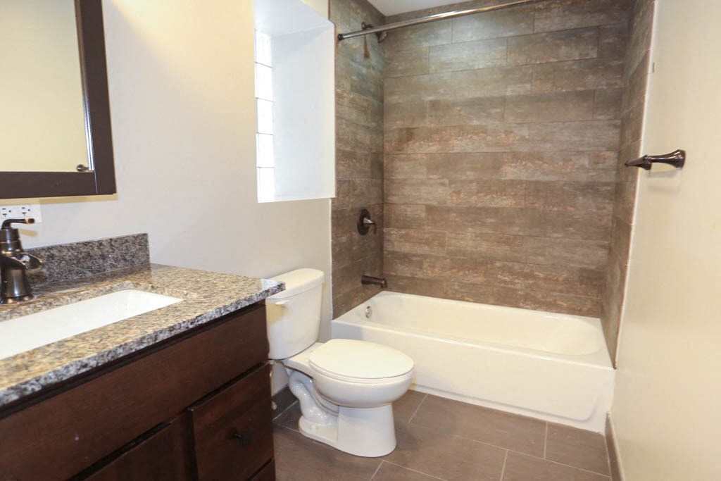 a bathroom with a toilet and a tub and a sink