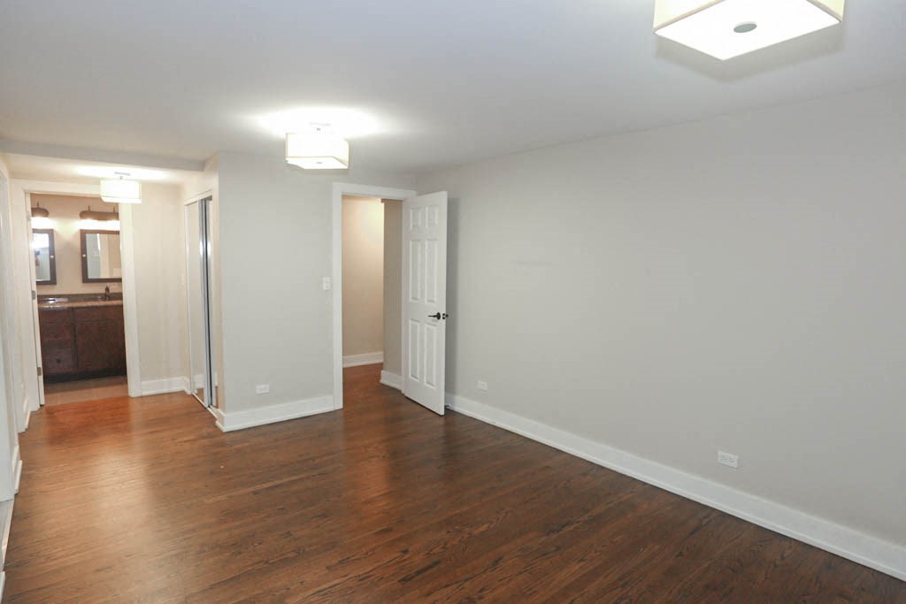 an empty living room with wood floors and white walls