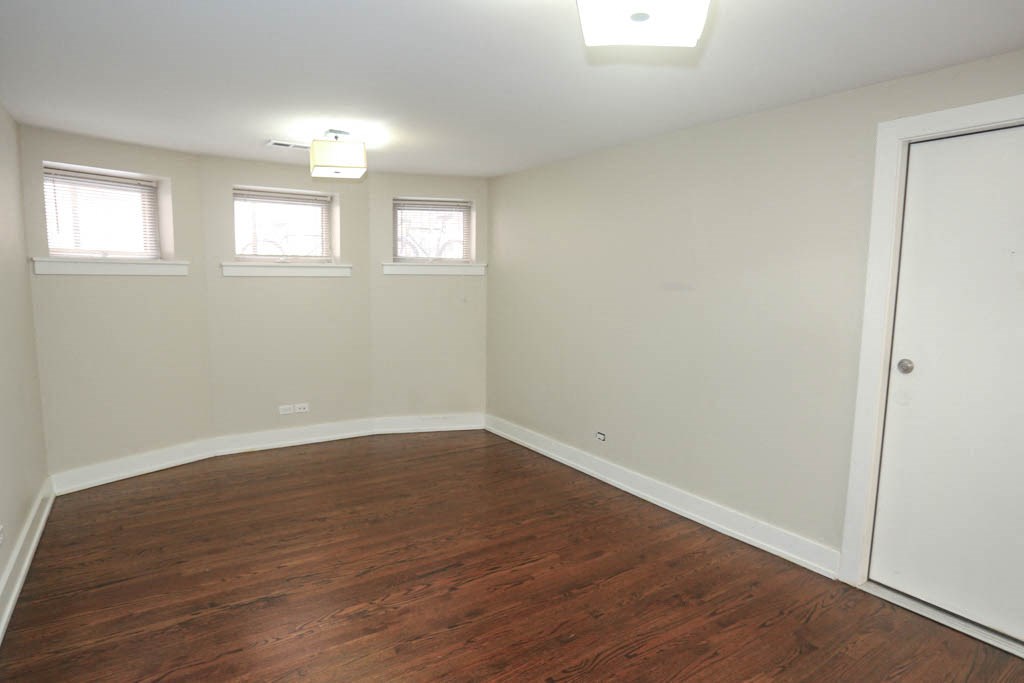 a bedroom with a hard wood floor and white walls