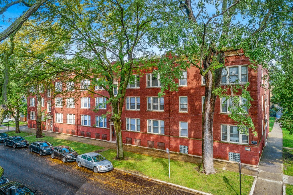 a red brick building with cars parked in front of it