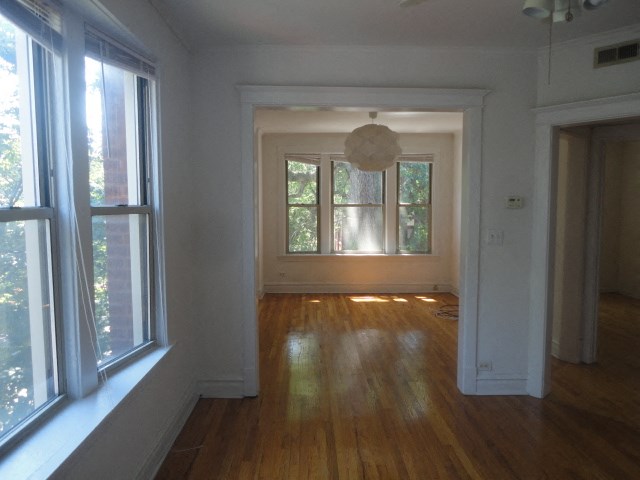 an empty living room with wood floors and windows