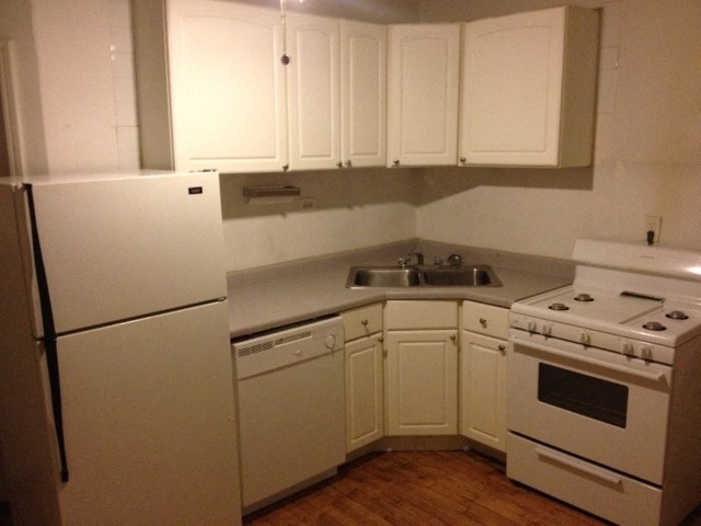 a kitchen with white appliances and white cabinets