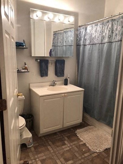 a bathroom with a sink and a shower and a toilet