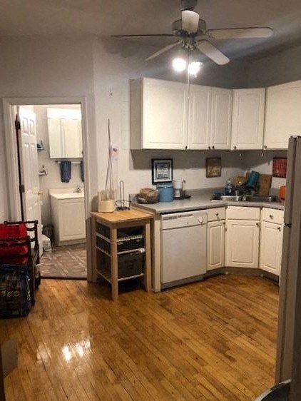 a kitchen with white cabinets and a wooden floor