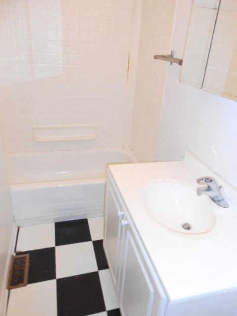 a bathroom with a white sink and a black and white checkered floor