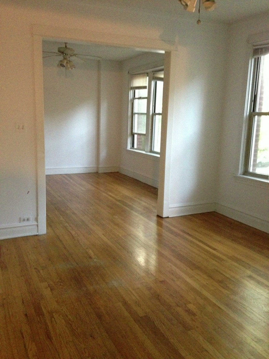 an empty living room with a hard wood floor