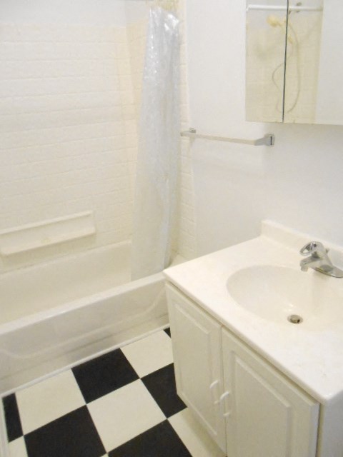 a bathroom with a white sink and a black and white checkered floor
