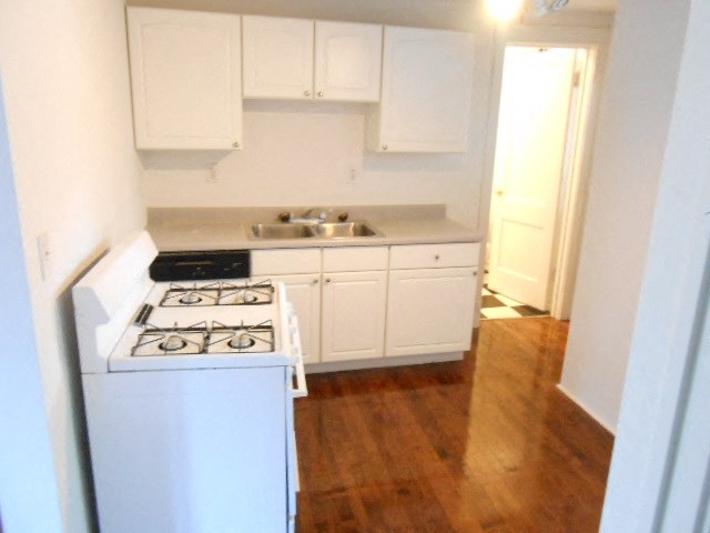 an empty kitchen with a stove and a sink