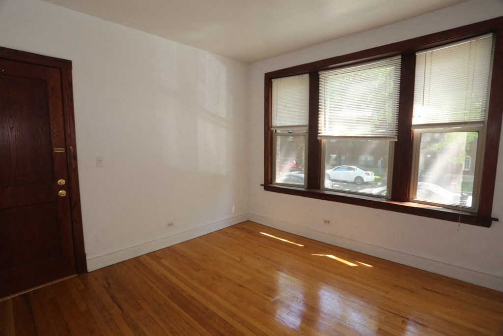 an empty room with a wooden floor and a window