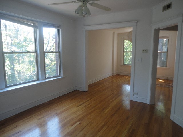 a living room with a hard wood floor and large windows