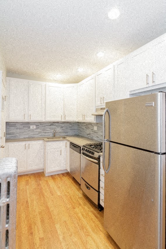 a kitchen with white cabinets and a stainless steel refrigerator
