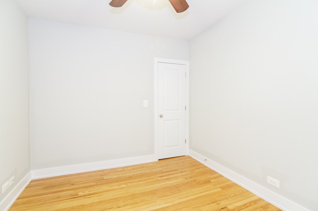 an empty room with white walls and a wooden floor