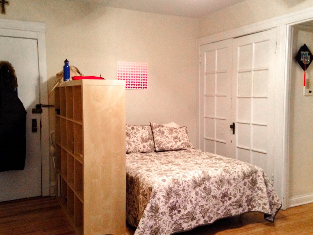 a small bedroom with a bed and a bookshelf
